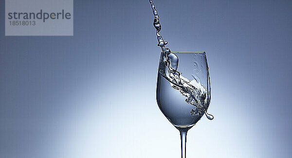 Studio shot of clear water pouring into wineglass