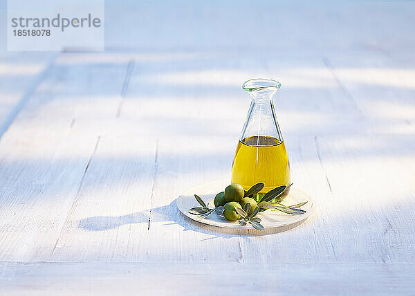 Carafe of olive oil on wooden coaster