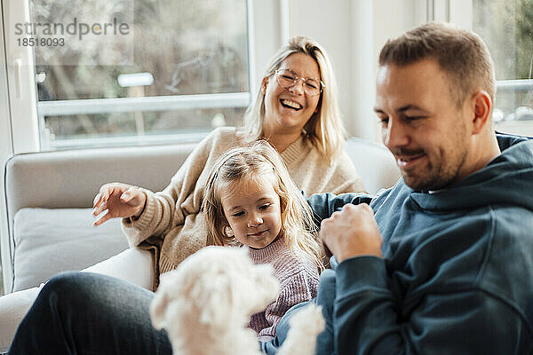 Happy family playing with dog at home