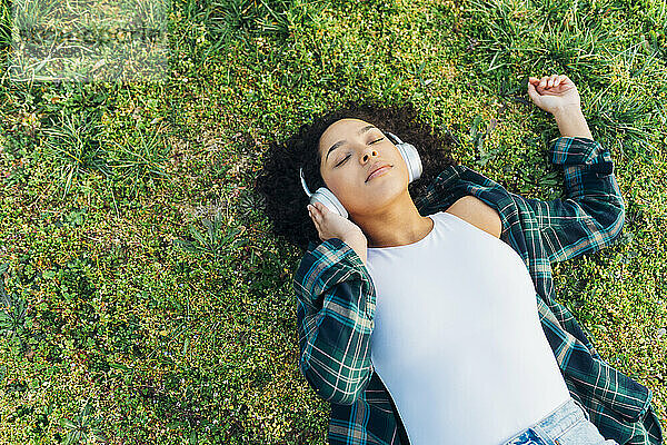Junge Frau mit geschlossenen Augen entspannt sich und hört Musik