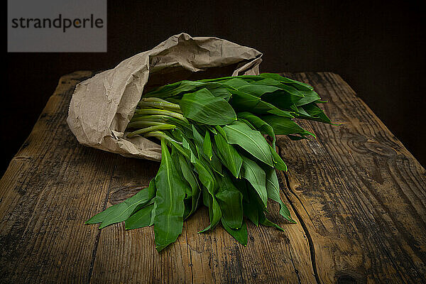 Fresh ramson in paper bag lying on wooden table
