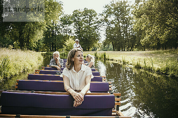 Touristen erkunden den Park Branitz sitzend im Boot auf dem See
