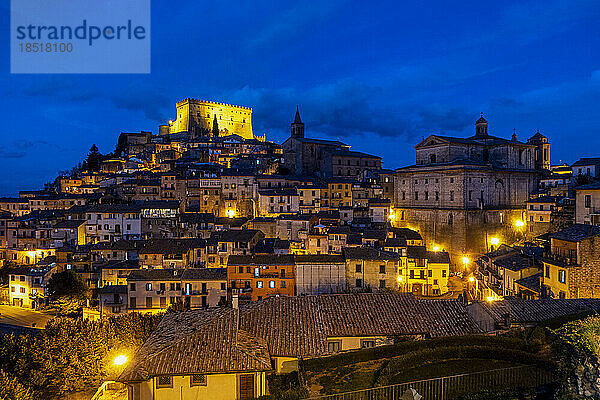 Beleuchtetes Castello Orsini über Häusern unter blauem Himmel in der Nacht