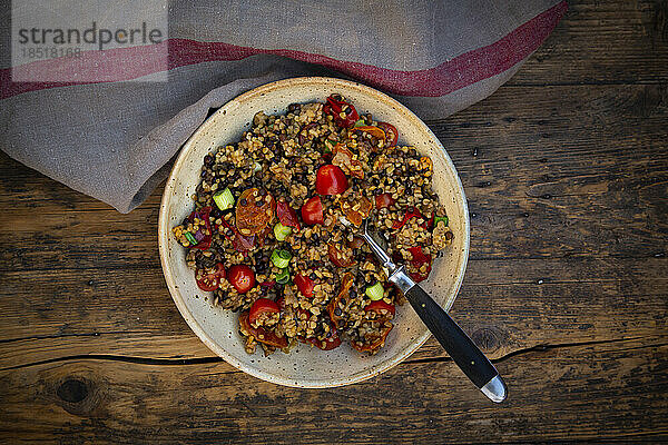 Bowl of Beluga lentils with bulgur  tomatoes  peppers  eggplant and scallion