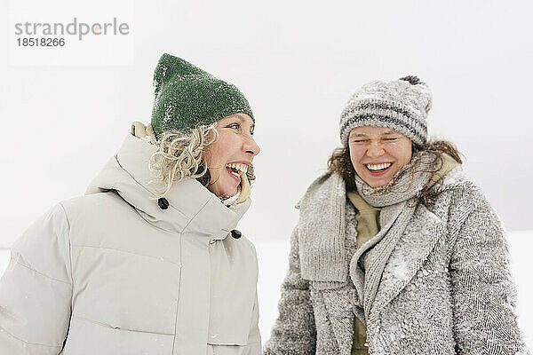 Fröhliche Frau genießt den Schnee mit ihrer Freundin