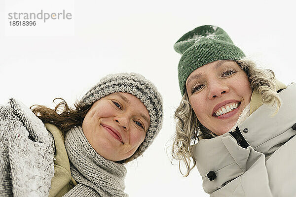 Fröhliche Freunde mit Strickmützen genießen den Winter