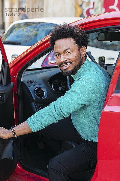 Lächelnder Mann öffnet Autotür