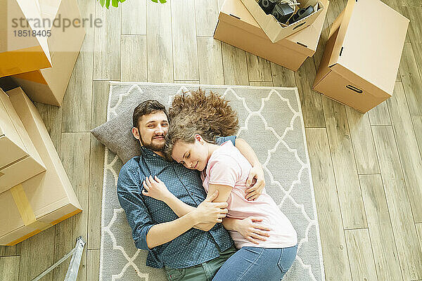 Couple resting on carpet in new home