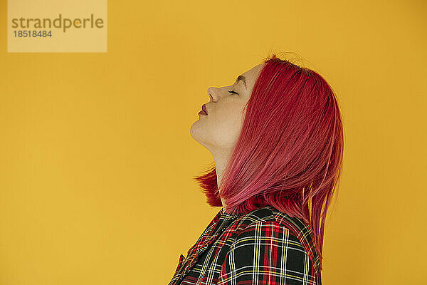Woman with pink dyed hair against colored background