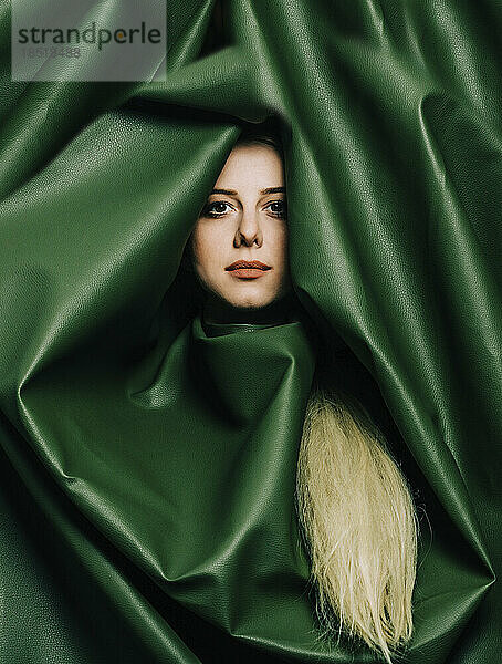 Beautiful woman wrapped in green leather