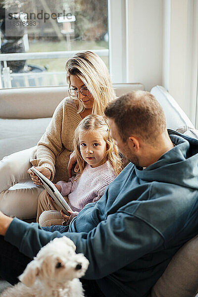 Mädchen mit Tablet-PC sitzt zu Hause bei den Eltern
