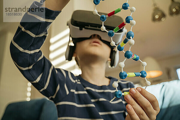 Junge untersucht zu Hause DNA-Modell durch VR-Brille