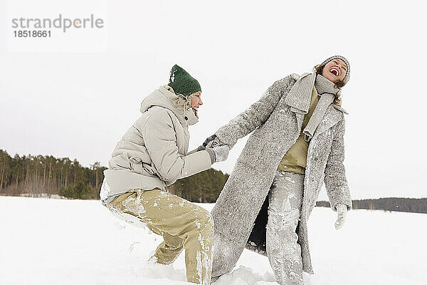 Friends having fun with each other in snow