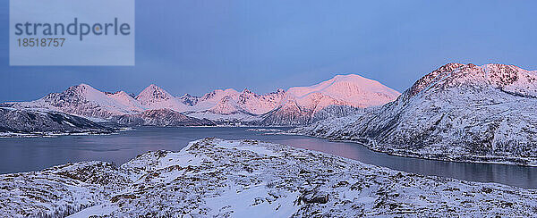 Norwegen  Troms und Finnmark  schneebedeckte Berge rund um den Sorfjord in der Abenddämmerung