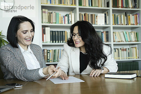 Glückliche Geschäftsfrauen planen Strategie bei Besprechung am Schreibtisch