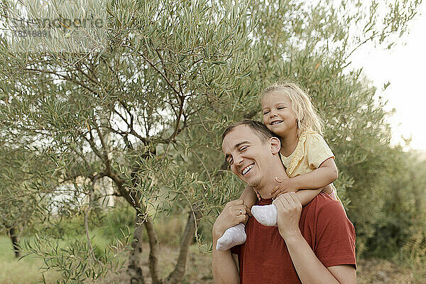 Glücklicher Vater und Tochter  die Spaß im Olivengarten haben