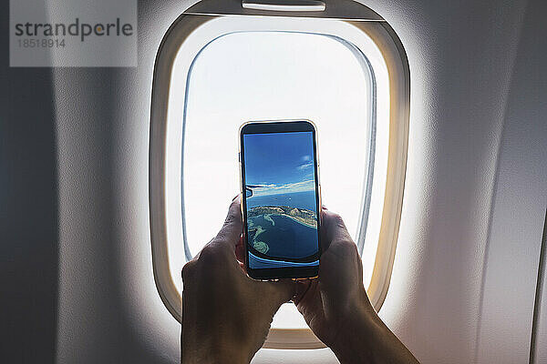 Mann fotografiert durch Flugzeugfenster