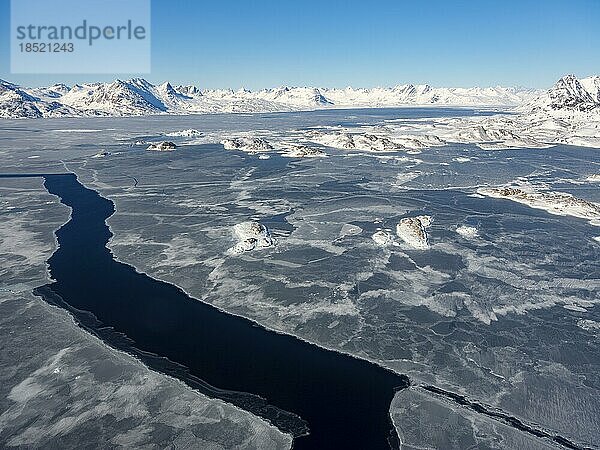 Luftaufnahme  Winterlandschaft  Blick von oben aufs teils gefrohrenes Meer  hinten Gebirge  Kulusuk  Ostgrönland  Grönland  Nordamerika