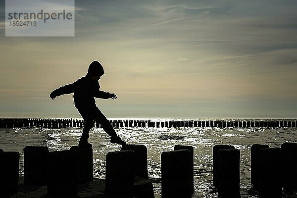 Symbolfoto zum Thema Mut von Kindern. Ein Kind balanciert auf Holzstelzen über das Wasser. Arenshoop  18.04.2022  Arenshoop  Deutschland  Europa