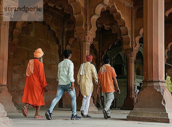 Indische Touristen gehen durch die roten Sandsteinkolonnaden des Diwan i Amm im Roten Fort  Delhi  Indien  Asien