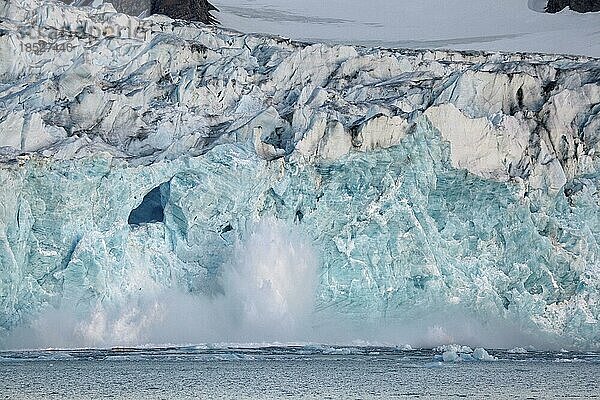 Ein großer Eisbrocken bricht von einem Gletscher ab und stürzt in den Magdalenefjord auf Svalbard  Spitzbergen  Norwegen  Europa