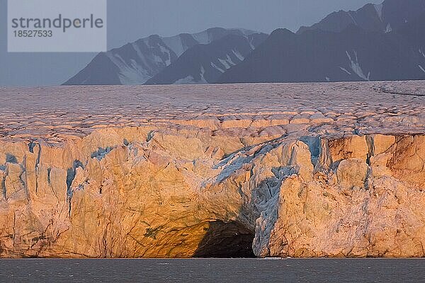 Eingang einer riesigen Eishöhle bei Sonnenuntergang im Kongsbreengletscher der in den Kongsfjorden kalbt  Svalbard  Spitzbergen  Norwegen  Europa
