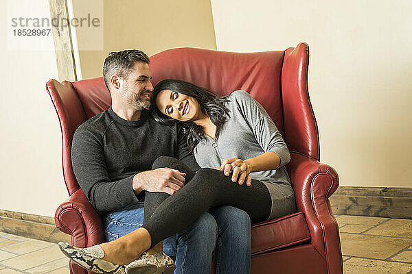 Fröhliches Paar entspannt sich gemeinsam im Sessel