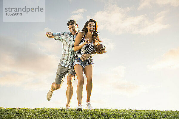 Mann und Frau spielen Ball im Park