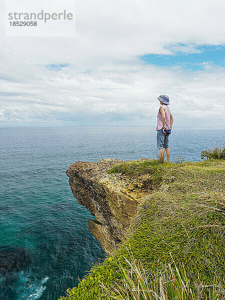 Australien  New South Wales  Port Macquarie  Frau steht auf einer Klippe und blickt auf die Aussicht