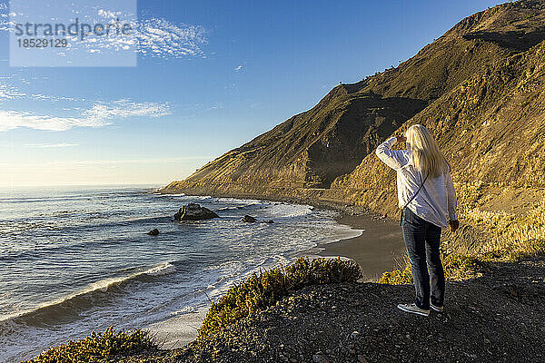 Vereinigte Staaten  Kalifornien  Big Sur  ältere blonde Frau blickt auf den Pazifischen Ozean