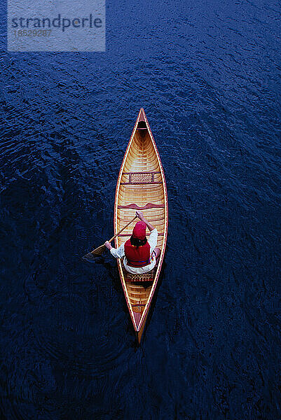 Blick von oben auf eine Frau  die auf dem Lake Placid Kanu paddelt