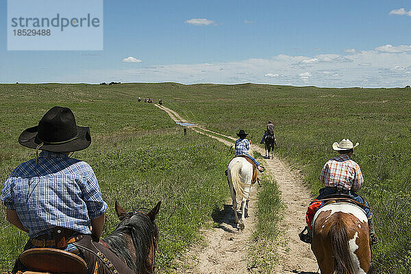 Mädchen und Jungen im Grundschulalter auf dem Pferderücken folgen einem Feldweg; Burwell  Nebraska  Vereinigte Staaten von Amerika