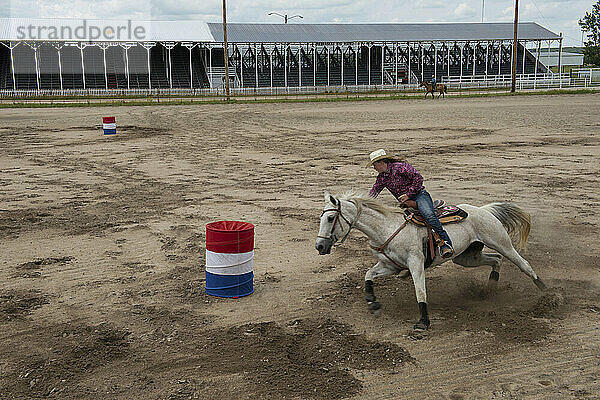 Ein junges Mädchen übt mit ihrem Pferd Fassrennen; Burwell  Nebraska  Vereinigte Staaten von Amerika