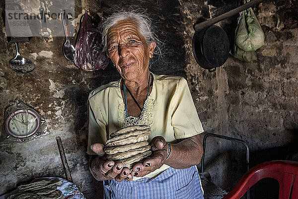 Ältere mexikanische Frau hält in ihrer Küche einen Stapel Fladenbrot in den Händen; Ejido Hidalgo  San Luis  Mexiko