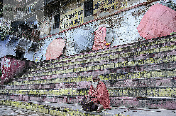 Sadhu sitzt auf den Ghats entlang des Ganges; Varanasi  Indien