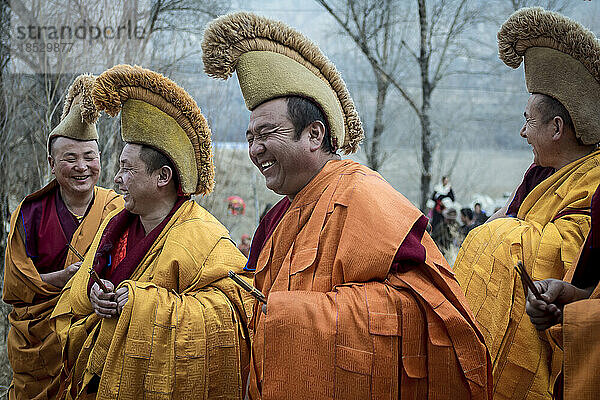 Vier Mönche stehen und lachen zusammen; Repkong  Amdo  China