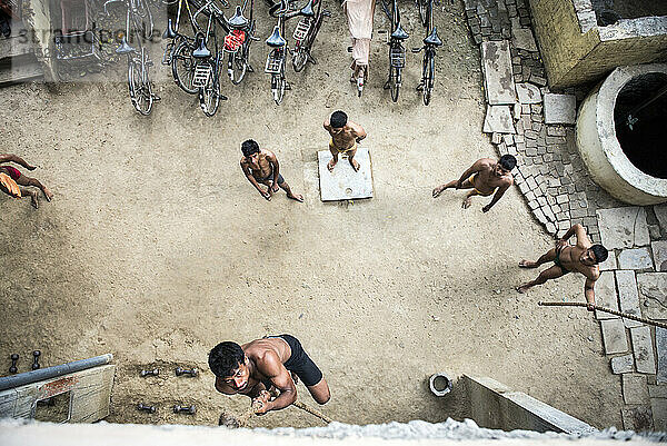 Blick von oben auf junge männliche Turner  die ein Seil hochklettern; Varanasi  Indien