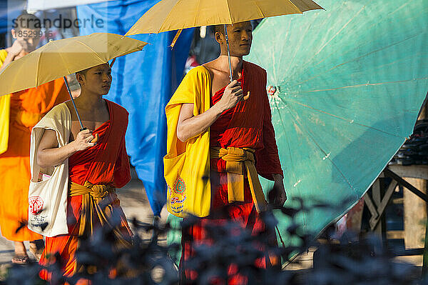 Mönche mit Regenschirmen auf der Straße; Luang Prabang  Laos