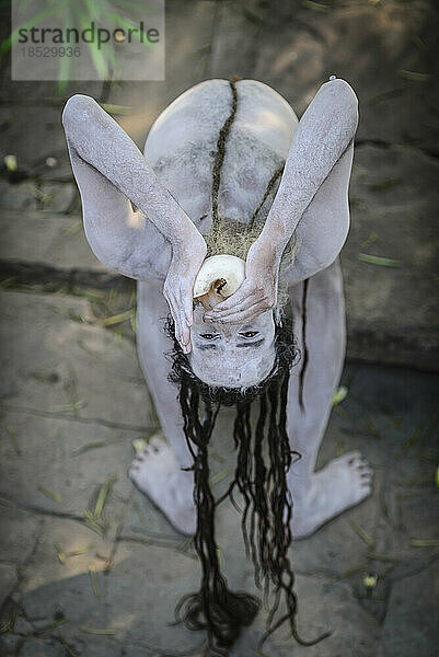 Sadhu bei der Durchführung von Ritualen mit einem mit Asche bemalten Körper; Varanasi  Indien