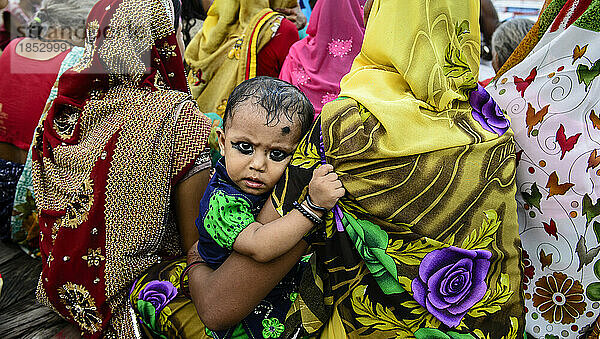 Kleines Mädchen mit geschminkten Augen  das von seiner Mutter gehalten wird; Varanasi  Indien