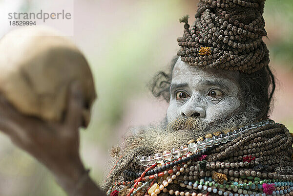 Sadhu bei der Betrachtung eines Schädels; Varanasi  Indien