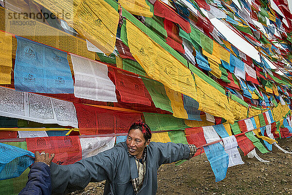 Pilger mit lächelnden Gebetsfahnen beim Saga-Dawa-Fest in Tibet; Autonome Region Tibet  Tibet