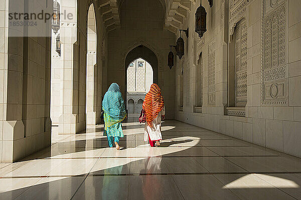 Zwei traditionell gekleidete Frauen gehen durch einen Korridor der Sultan-Qaboos-Großmoschee; Muscat  Oman