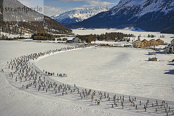 Luftaufnahme einiger der 16.000 Teilnehmer des Skimarathons  die mit ihren nordischen Skiern über das gefrorene Oberengadiner Tal wandern. Die Winterveranstaltung findet seit 1969 statt und zieht Athleten und Touristen in die Berggemeinden rund um Sankt Moritz in den Schweizer Alpen.