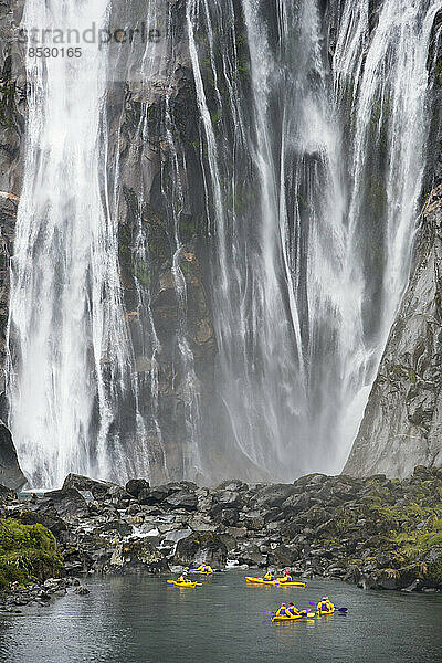 Kajakfahrer machen eine Pause am Fuße der Lady Bowen Falls; Milford Sound  Neuseeland