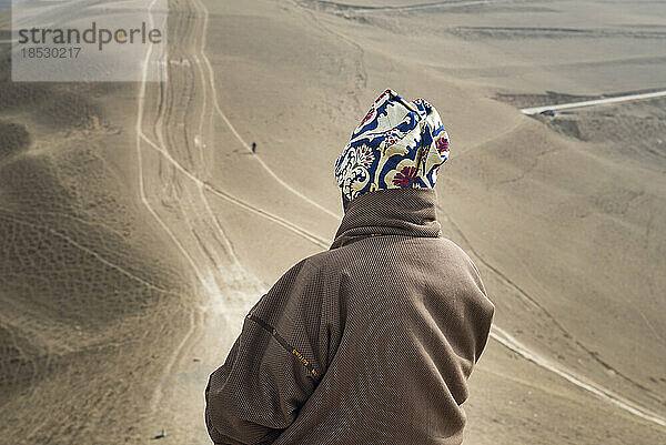 Ein buddhistischer Pilger blickt von einer Anhöhe aus über die trockene Landschaft; Amdo  China