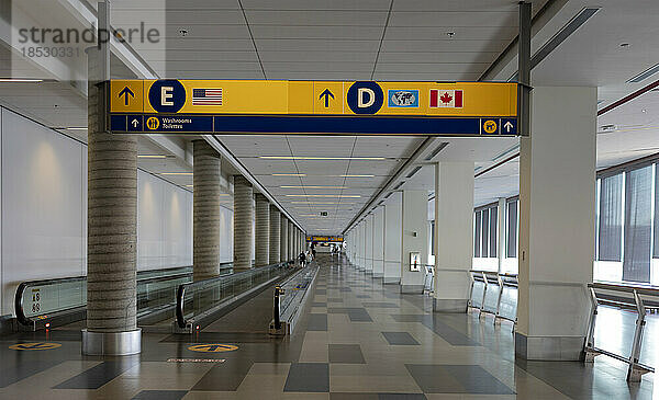 Fahrsteig und Beschilderung für den nationalen und internationalen Verkehr über einem Korridor in einem Flughafen; Calgary  Alberta  Kanada