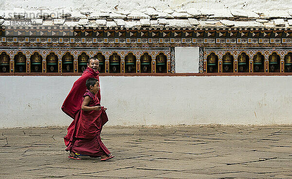 Zwei junge Mönche beim Gang durch ein Kloster; Paro-Tal  Bhutan