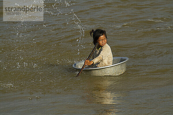 Ein Kind wird in einem Boot auf dem Großen See oder Tonle Sap bespritzt; Tonle Sap  Kambodscha