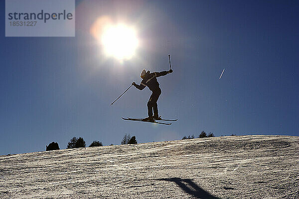 Skifahrer beim Springen im Skigebiet von Seis in Italien; Seis am Schlern  Südtirol  Italien